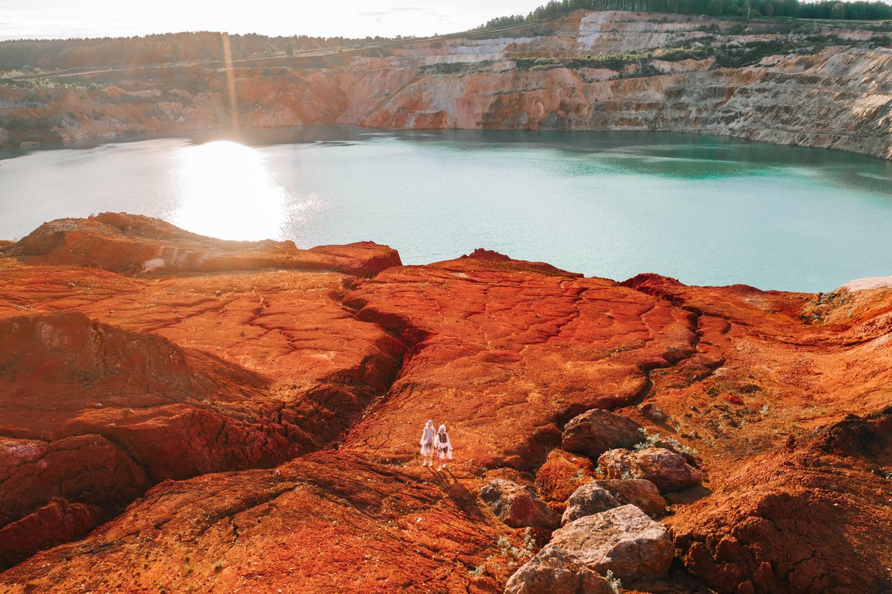 Drone shot capturing a vibrant quarry lake and rocky terrain in Guryevsky District, Russia.